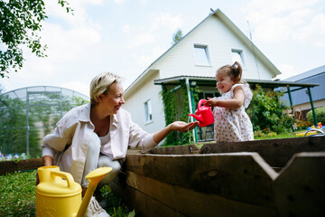 Mom and daughter watering the garden