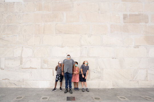 Father and children stand at base of Washington monument and look up