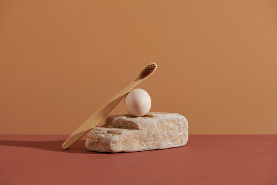 eco-friendly bamboo toothbrushes balanced on a wooden ball