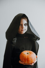 Scary boy holds pumpkins for halloween celebration