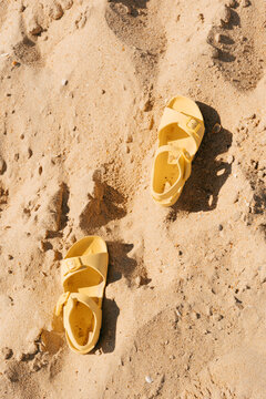 Beach sandals on the sand top view