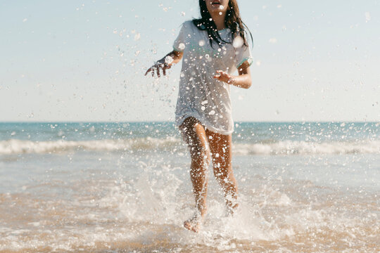 Preteen girl running along the shore