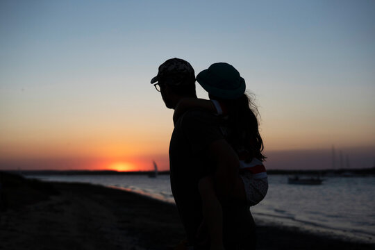 Father with his daughter enjoying the sunset at the beach