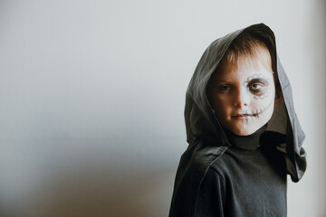 Scary boy celebrating halloweenday of the dead terrifying skull face makeup for eyes mouth