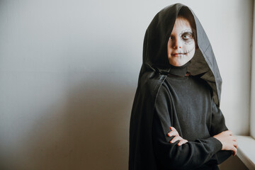 Scary boy celebrating halloweenday of the dead terrifying skull face makeup for eyes mouth