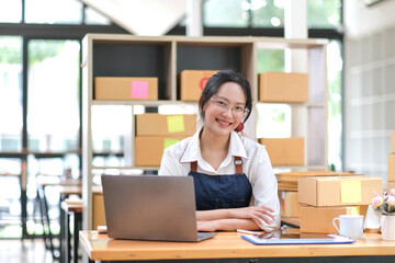 Portrait of Asian young woman working with a box at home the workplace.start-up small business owner, small business entrepreneur SME or freelance business online and delivery concept.