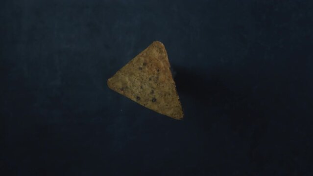 One doritos chips  burned by the flame of a torch burner, slow motion top down shot