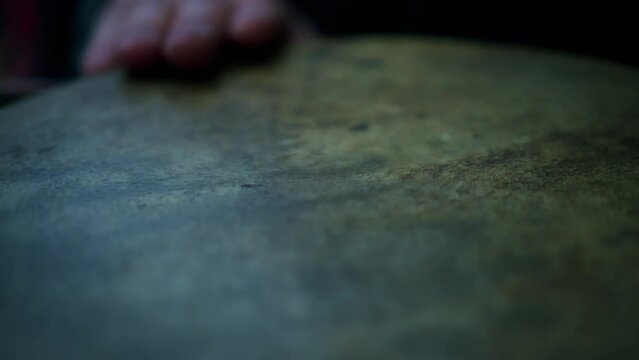 Close up of person with traditional medieval costume playing on old leather drum in slow motion 