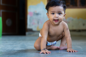 child playing on the floor wear diaper