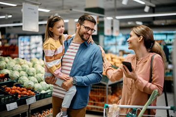 Happy family talk while shopping together in supermarket.
