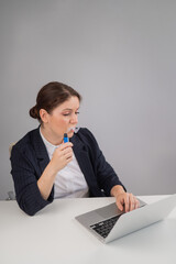 Business woman smoking a disposable vape while sitting at her desk. 