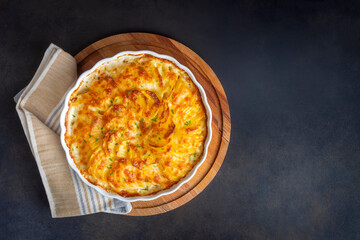 Potato gratin - graten (baked potatoes with cream and cheese) with rosemary and forks (Turkish name; Kremali patates)