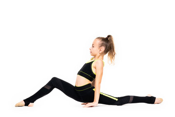 Plakat Gymnastic exercises. Flexible little girl gymnast in a sports black suit sits on a twine, isolated on a white background