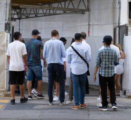 Rear view of multiethnic people walking surrounded by scaffold in a city