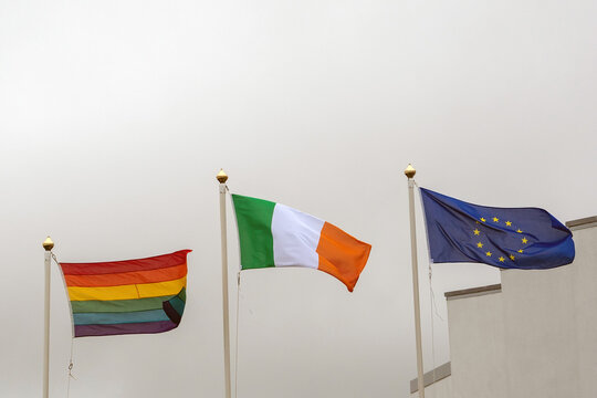 Waving flag LGBT and Euro Union and Republic of Ireland on grey sky background.