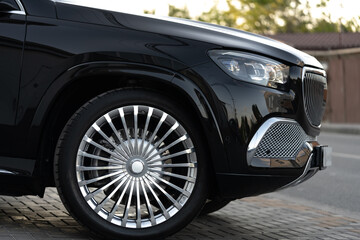 Aluminium rim of luxury black suv car wheel close up