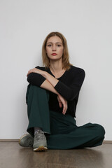 Serie of studio photos of young female model wearing simple comfortable outfit, organic cotton blouse and green trousers