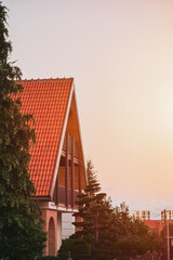 Family cottage against evening sky. Close up of a house details, windows, roof and facade.