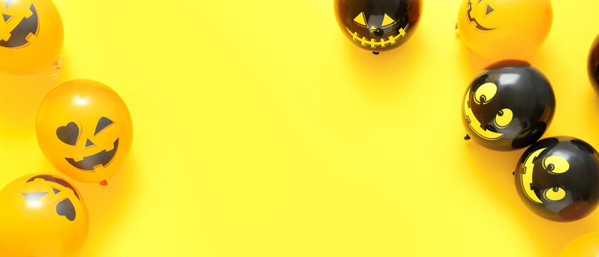 Funny Halloween balloons on yellow background with space for text