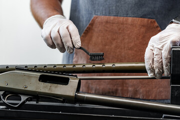 The gunsmith maintaining his rifle in a workshop