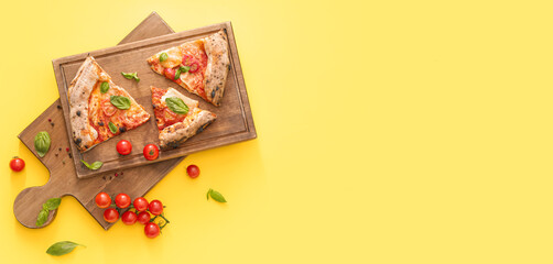 Boards and slices of delicious pizza Margherita on yellow background with space for text, top view