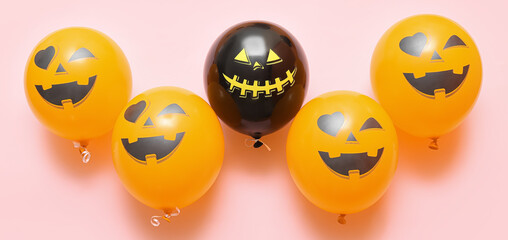 Funny Halloween balloons on pink background, top view
