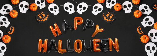 Text HAPPY HALLOWEEN made of balloons, pumpkins and paper garland on black background