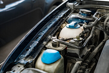 View of engine and other parts under the open hood of a car
