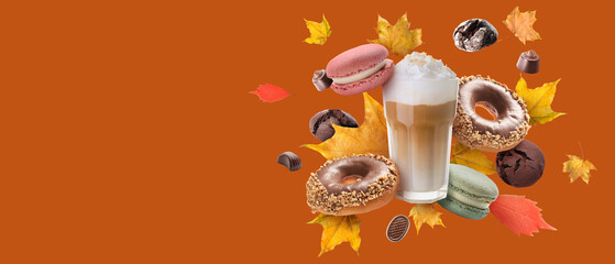 Glass of latte, sweets and autumn leaves on orange background with space for text