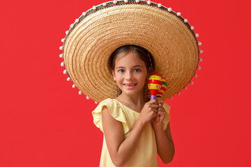 Happy little Mexican girl in sombrero hat with maracas on red background