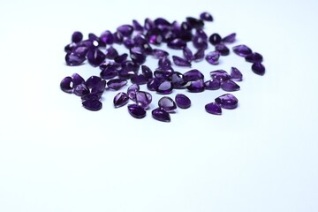 Amethyst gemstone or violet sapphire with dark purple color on white background. February birth gems
