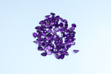 Amethyst gemstone or violet sapphire with dark purple color on white background. February birth gems
