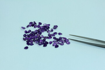 Amethyst gemstone or violet sapphire with dark purple color on white background. February birth gems