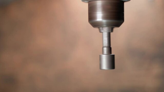 A close-up hexagon socket on a screwdriver is spinning in a drill chuck against a blurred background. Nozzle for loosening nuts on a wrench. top view, copyspace