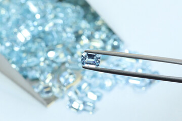 Blue aquamarine or blue topaz gemstone with light blue color on silver tray