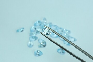 Blue aquamarine or blue topaz gemstone with light blue color on silver tray