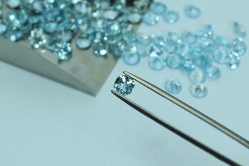 Blue aquamarine or blue topaz gemstone with light blue color on silver tray
