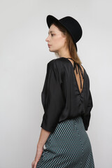 Serie of studio photos of attractive young female model wearing black blouse and geometric printed...
