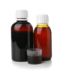 Bottles of cough syrup and cup on white background