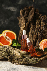 Composition with bottles of essential oil and tree bark on table