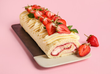 Plate with tasty strawberry roll cake on pink background