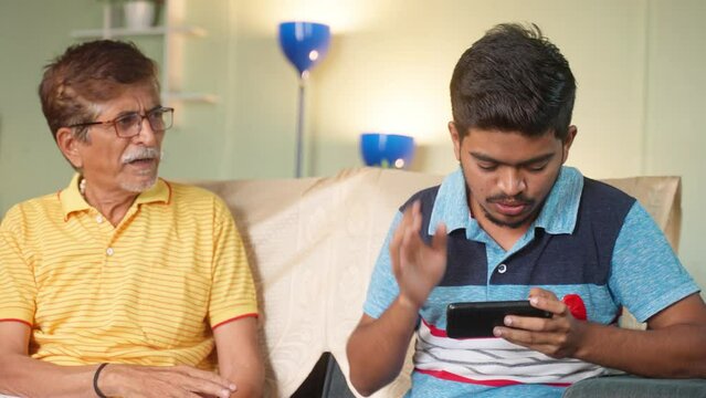 angry frustrated father about sons mobile phone video gaming addiction at home - concpet of technology, caring father and modern lifestyle