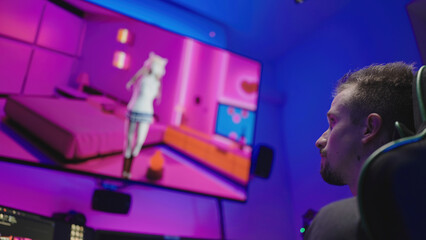 Male weeb absorbed in watching anime girl on big TV from gaming chair