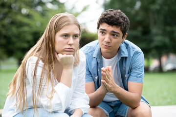 Hispanic teenager boy asking for forgiveness at girlfriend. Love relationship in adolescence concept
