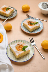 Plates with pieces of delicious apricot pie on color background