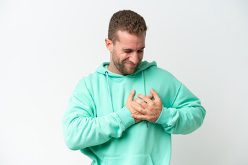 Young handsome caucasian man isolated on white background having a pain in the heart