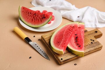 Plate, board with slices of watermelon and knife on beige background