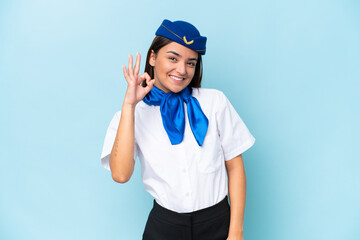 Airplane stewardess caucasian woman isolated on blue background showing ok sign with fingers
