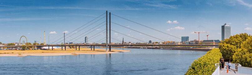 23 July 2022, Dusseldorf, Germany: Panoramic cityscape view of Suspension automobile bridge Rheinkniebrucke over the Rhine River