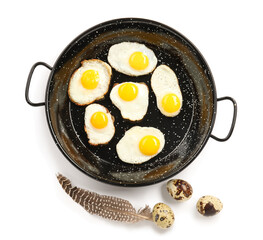 Frying pan with fried quail eggs isolated on white background